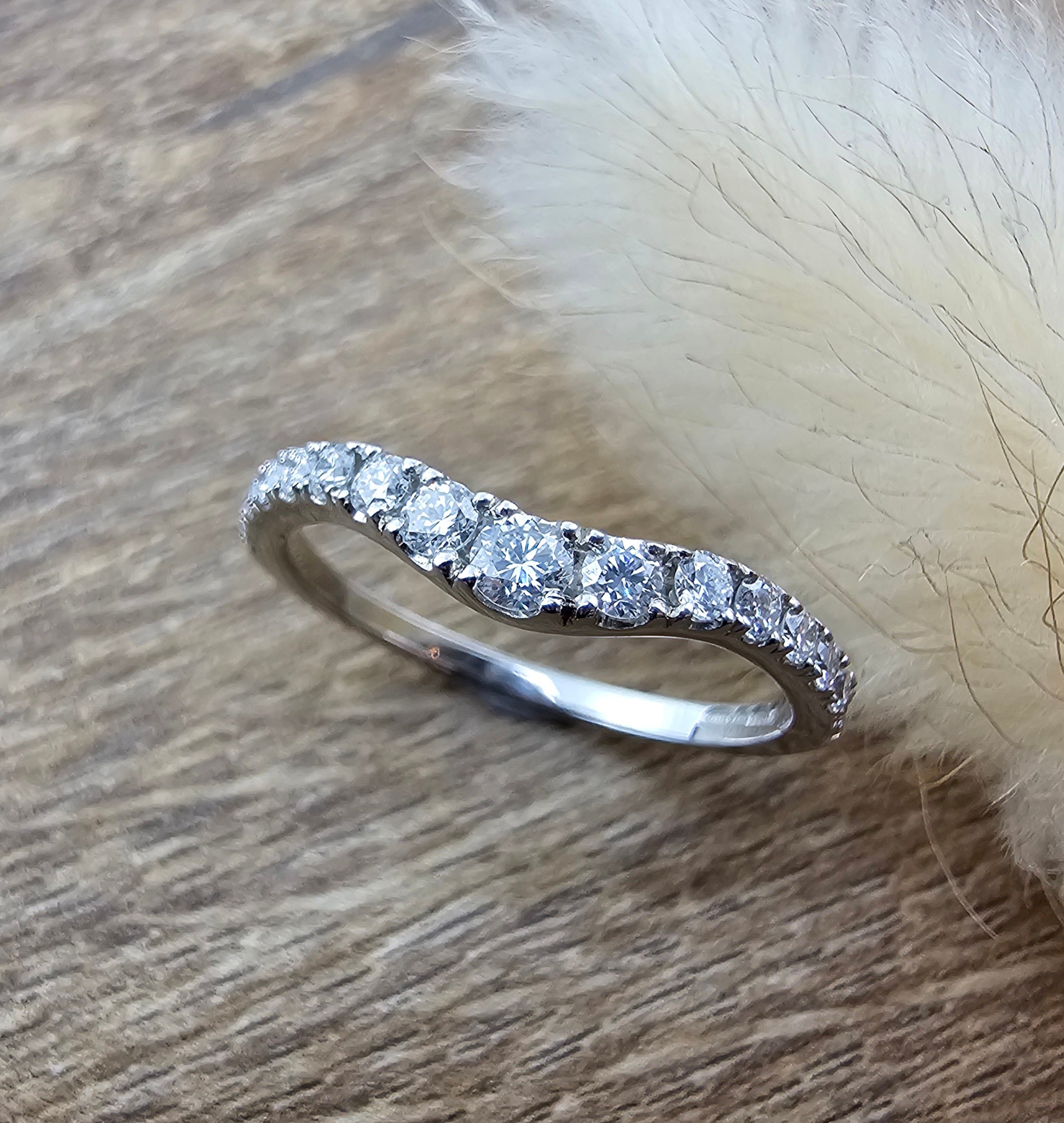 Platinum claw set curved diamond band