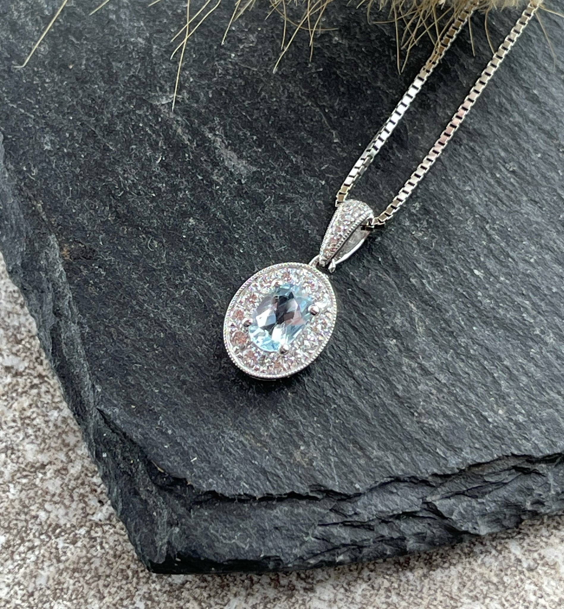 Oval aquamarine and diamond halo pendant