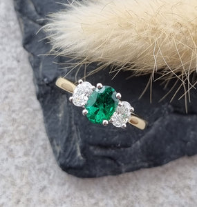 Oval emerald and oval diamond trilogy ring